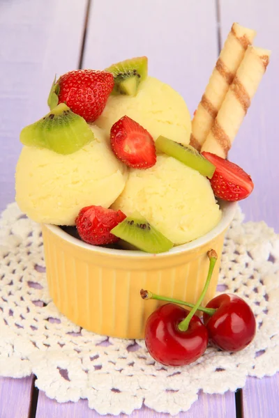 Delicioso helado con frutas y bayas en un tazón sobre una mesa de madera —  Fotos de Stock