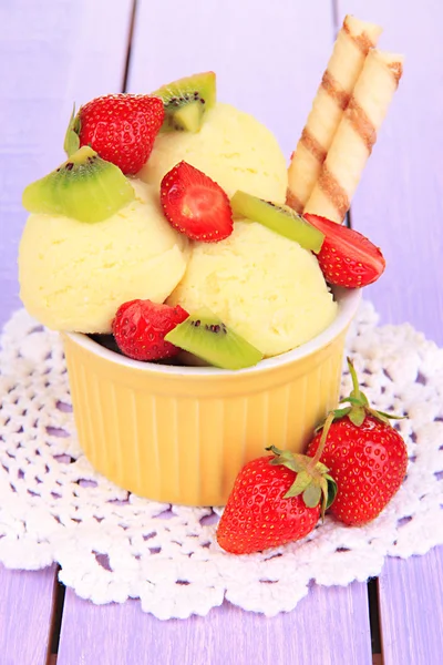 Delicioso helado con frutas y bayas en un tazón sobre una mesa de madera —  Fotos de Stock