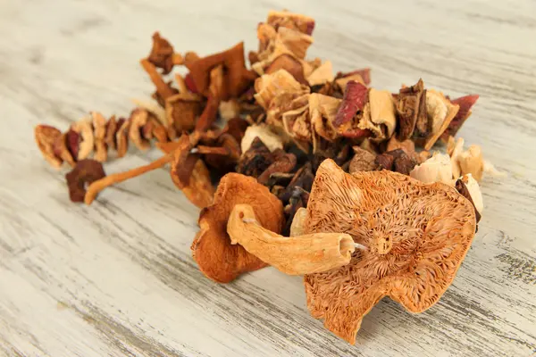 Cogumelos secos no fundo de madeira — Fotografia de Stock