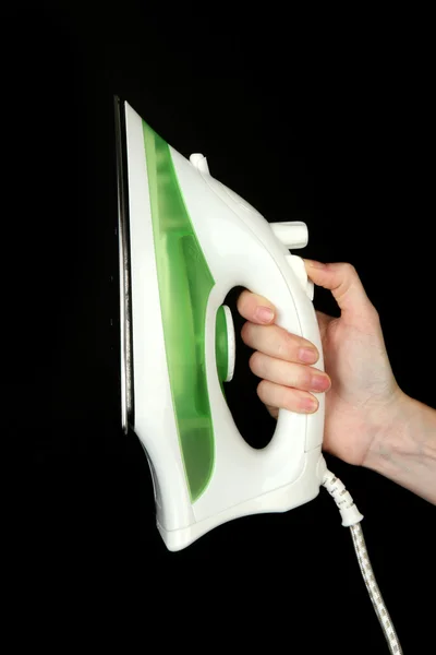 Steam iron in hand, isolated on black — Stock Photo, Image