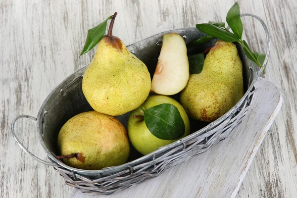 Pears in basket on board on wooden table — Stock Photo, Image