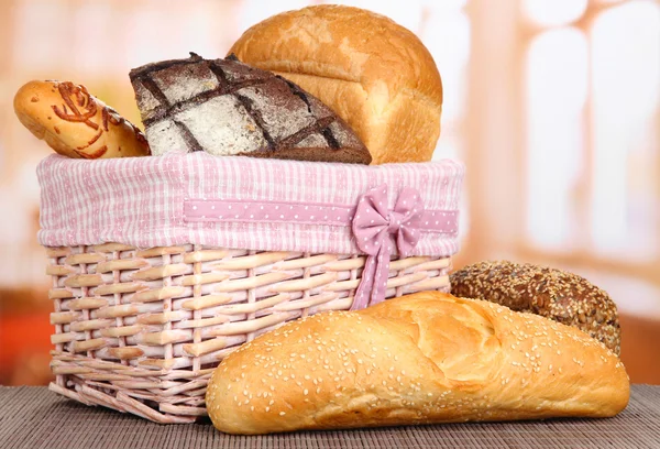 Выпечка хлеба в плетеной корзине на фоне окна — стоковое фото