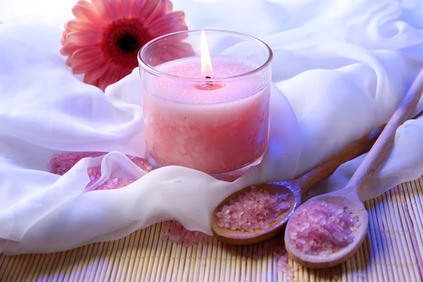 Beautiful candle with flower on white cloth, close up — Stock Photo, Image