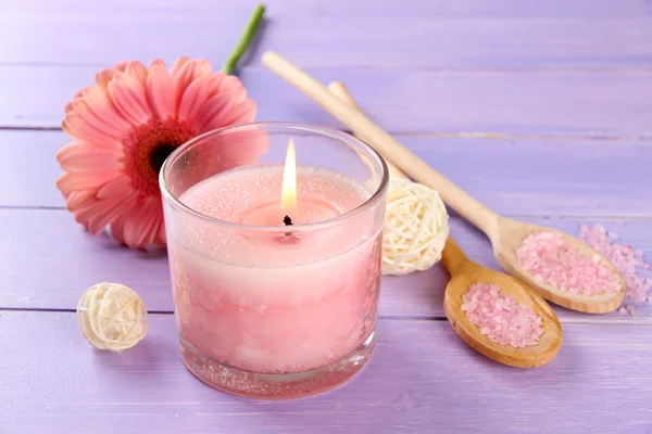 Hermosa vela rosa con flor sobre fondo de madera púrpura — Foto de Stock