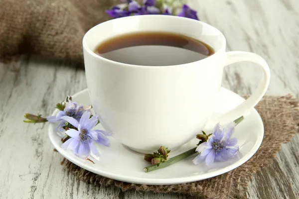 Cup of tea with chicory, on wooden background — Stock Photo, Image