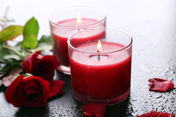 Beautiful romantic red candles with flowers, close up — Stock Photo, Image