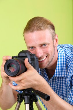 kamera ve tripod, yeşil zemin üzerine yakışıklı fotoğrafçı