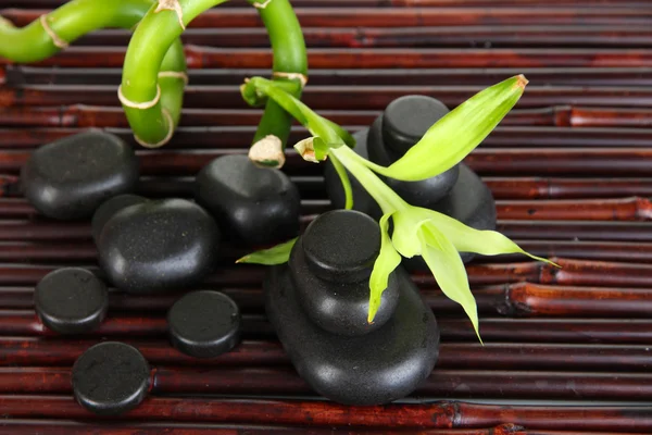 Wellness-Steine und Bambus auf Bambusmatte Hintergrund — Stockfoto