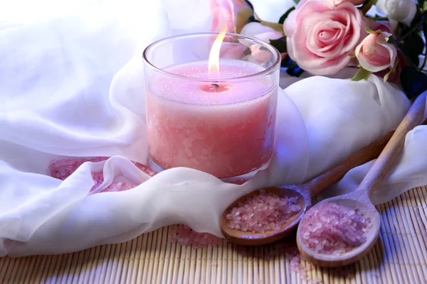 Schöne Kerze mit Blumen auf weißem Tuch, Nahaufnahme — Stockfoto
