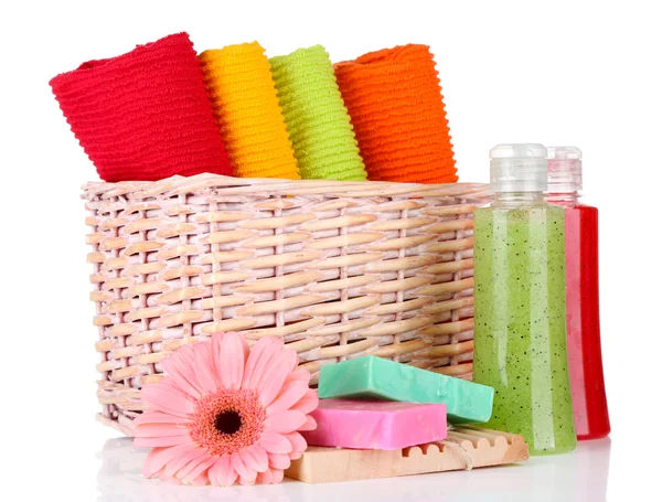 Colorful towels in basket, cosmetics bottles and soap, isolated on white — Stock Photo, Image