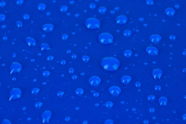 Gotas de agua sobre fondo plástico azul —  Fotos de Stock