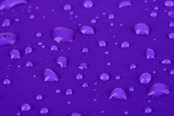 Gouttes d'eau sur fond plastique violet — Photo