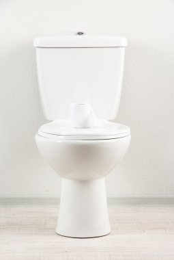 Banyoda tuvalet kağıdı olan beyaz klozet.