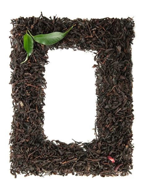 Çerçeve üzerinde beyaz izole yeşil yaprakları ile kuru siyah çay — Stok fotoğraf