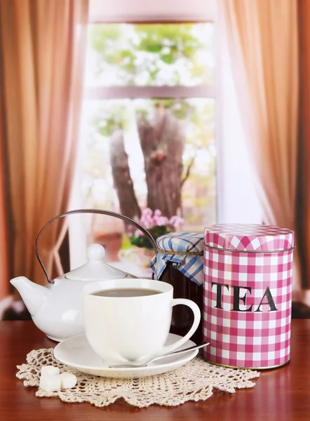 Kruik en kopje thee op tafel op kamer — Stockfoto