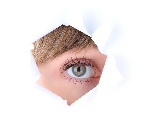 Female eye looking through hole in sheet of paper — Stock Photo, Image