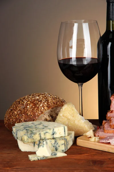 Exquisito bodegón de vino, queso y productos cárnicos — Foto de Stock