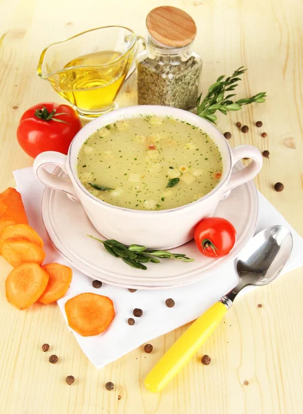 Sopa nutritiva en sartén rosa con ingredientes en la mesa de madera de cerca — Foto de Stock