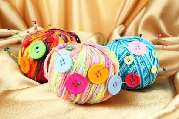 多彩按钮和多色毛球，彩色织物背景上 — 图库照片