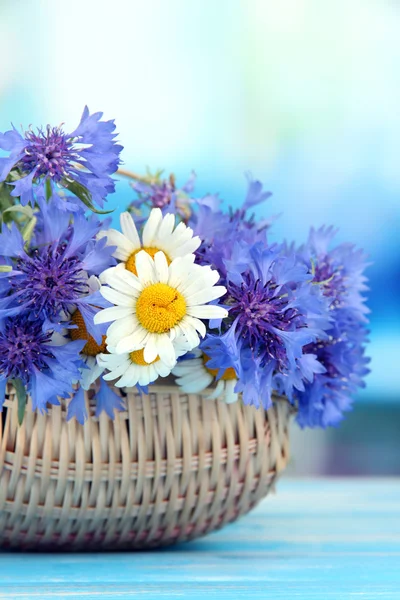 ヤグルマギクの青色の背景にバスケットに鎮静の美しい花束 — ストック写真
