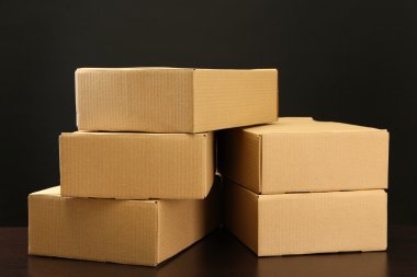 siyah arka plan üzerine ahşap masa üstünde parsel