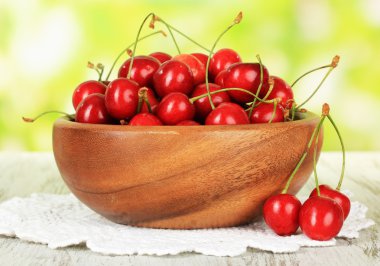 parlak zemin üzerine ahşap masa üzerinde kase kiraz meyveleri