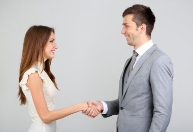 gri zemin üzerine el sıkışan iş arkadaşları