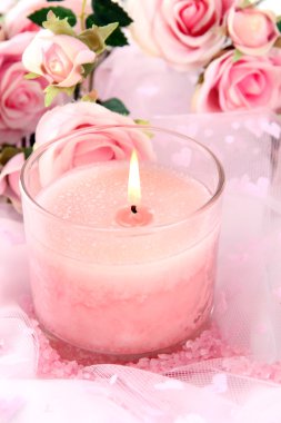 Beyaz kumaş üzerine çiçekli güzel mum yakın çekim