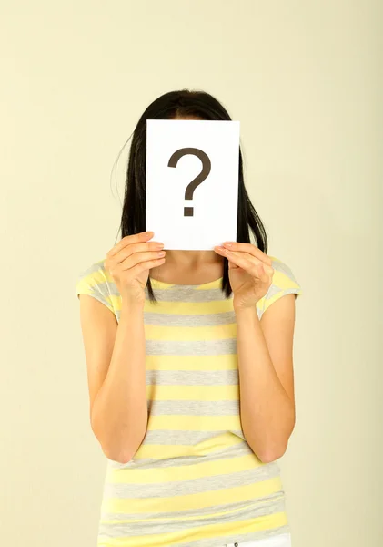 Woman with question marks on grey background — Stock Photo, Image