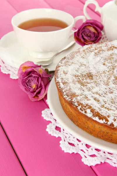Läcker vallmo frön tårta med kopp te på bordet närbild — Stockfoto