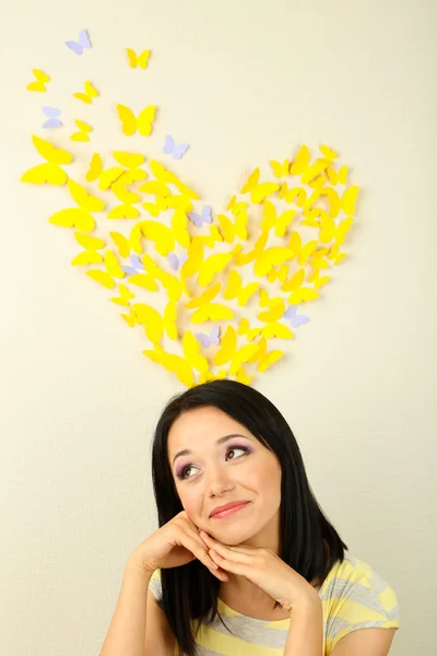 Girl near paper butterflies fly on wall — Stock Photo, Image