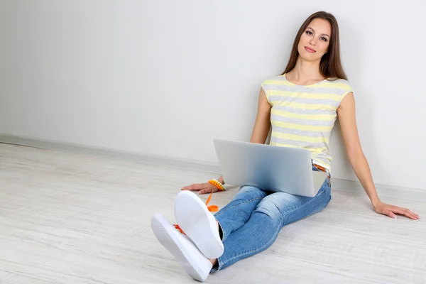 Mulher bonita sentada com laptop no quarto — Fotografia de Stock