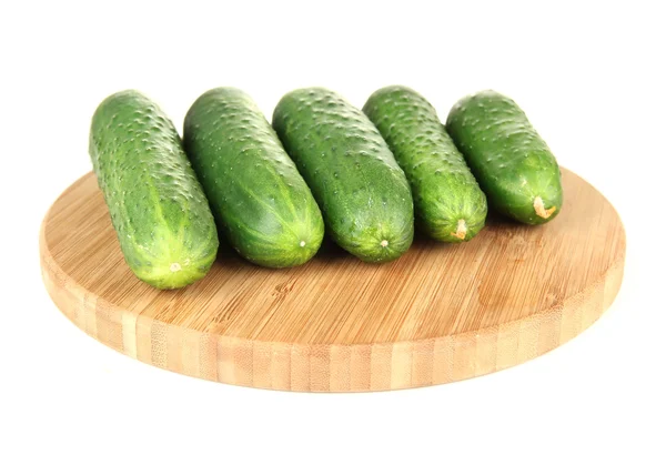 Pepinos verdes saborosos em tábua de corte de madeira, isolados em branco — Fotografia de Stock