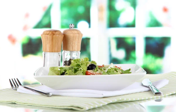 Leichter Salat auf Teller auf Serviette auf Fensterhintergrund — Stockfoto