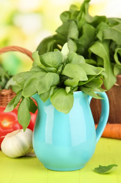 Fresh herb in pitcher on wooden table on natural background — Stock Photo, Image