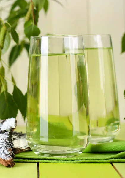 Vasos de savia de abedul sobre mesa de madera verde —  Fotos de Stock