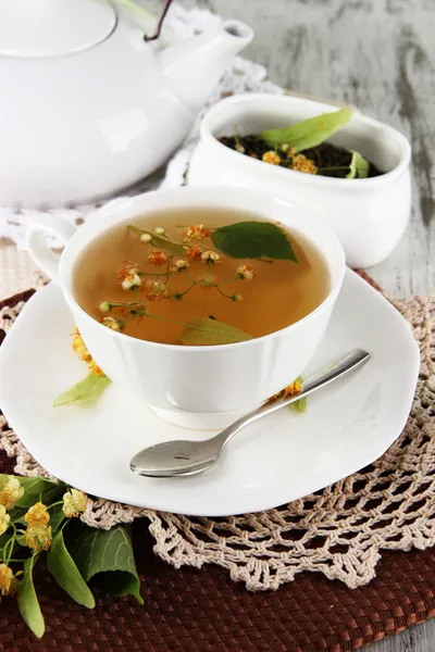 Kopje thee met linden op servetten op houten tafel — Stockfoto