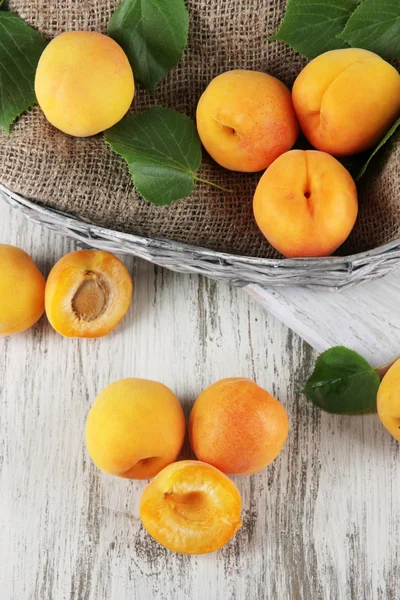 Apricots in basket on wooden table — Stock Photo, Image