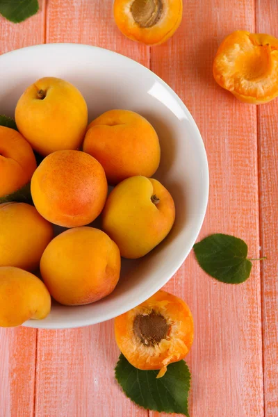 Aprikosen im Teller auf Holztisch — Stockfoto