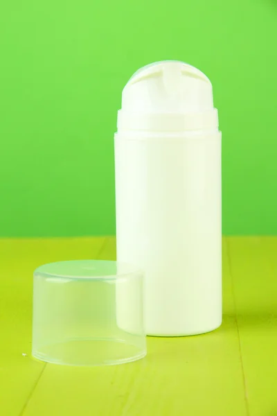 Bottle with cream, on color background — Stock Photo, Image