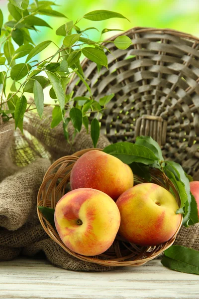 Dojrzałe słodkie brzoskwinie na drewnianym stole w ogrodzie, z bliska — Zdjęcie stockowe