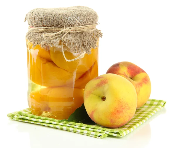 Jar of canned peaches and fresh peaches, isolated on white — Stock Photo, Image