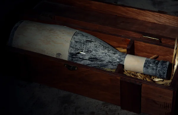 Vieja botella de vino en caja de madera, sobre fondo marrón oscuro — Foto de Stock