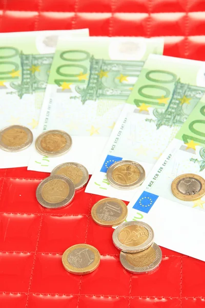 Euro banknotes and euro cents on red background — Stock Photo, Image