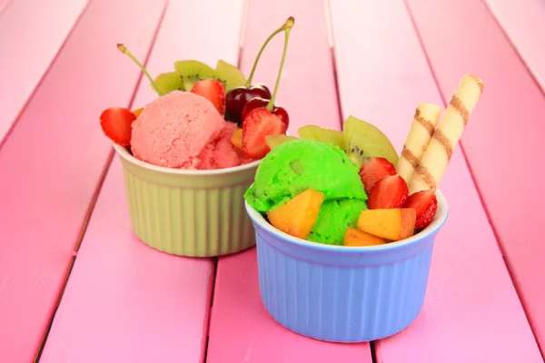 Leckeres Eis mit Früchten und Beeren in Schüssel auf Holztisch — Stockfoto