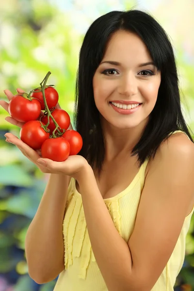 Ragazza con pomodori freschi su sfondo naturale — Foto Stock