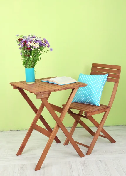 Mesa de madeira com flor e livro sobre ele no quarto — Fotografia de Stock