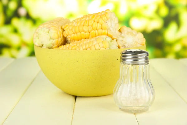 Варёная кукуруза в миске, на деревянном столе, на ярком фоне — стоковое фото