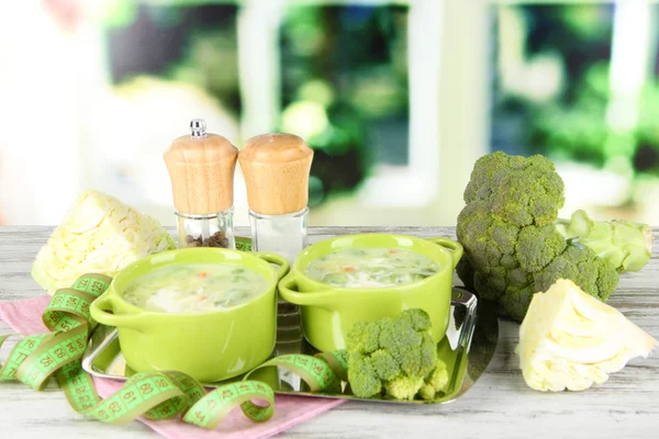 Cabbage soup in plates on metal tray on napkin on wooden table on window background — Stock Photo, Image