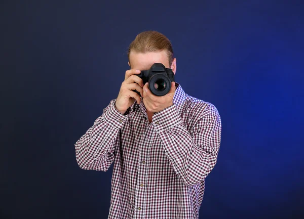 Schöner Fotograf mit Kamera, auf dunklem Hintergrund — Stockfoto